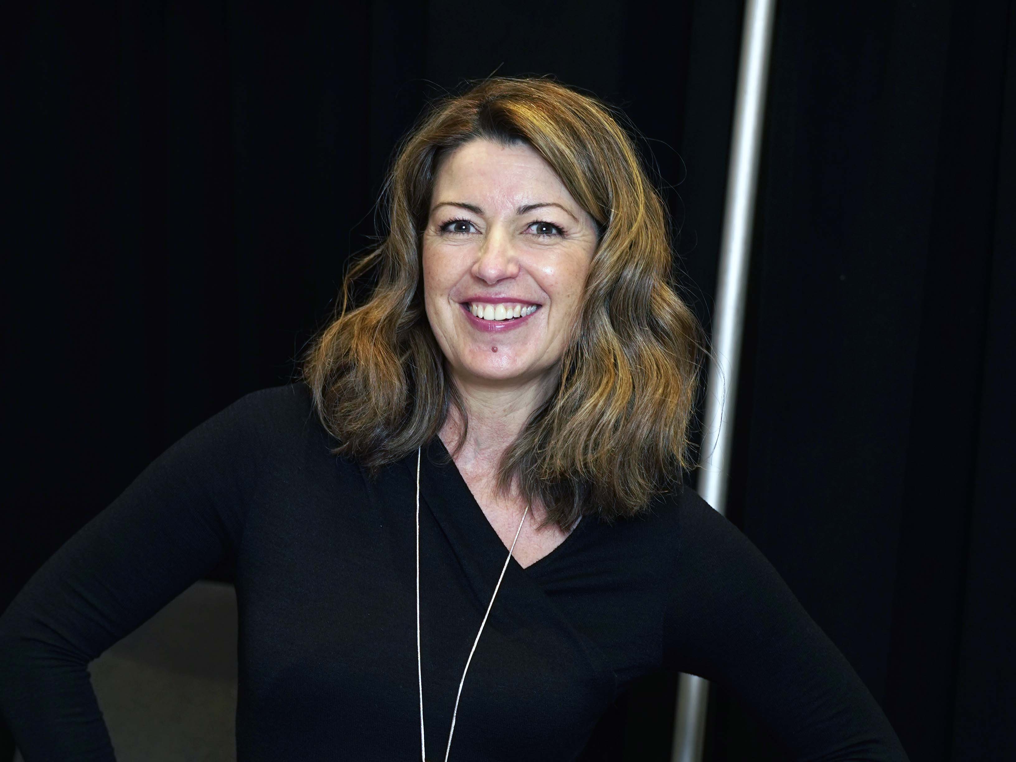 KATIE GRIFFIN POSING FOR A PHOTO WITH A BLACK BACKGROUND