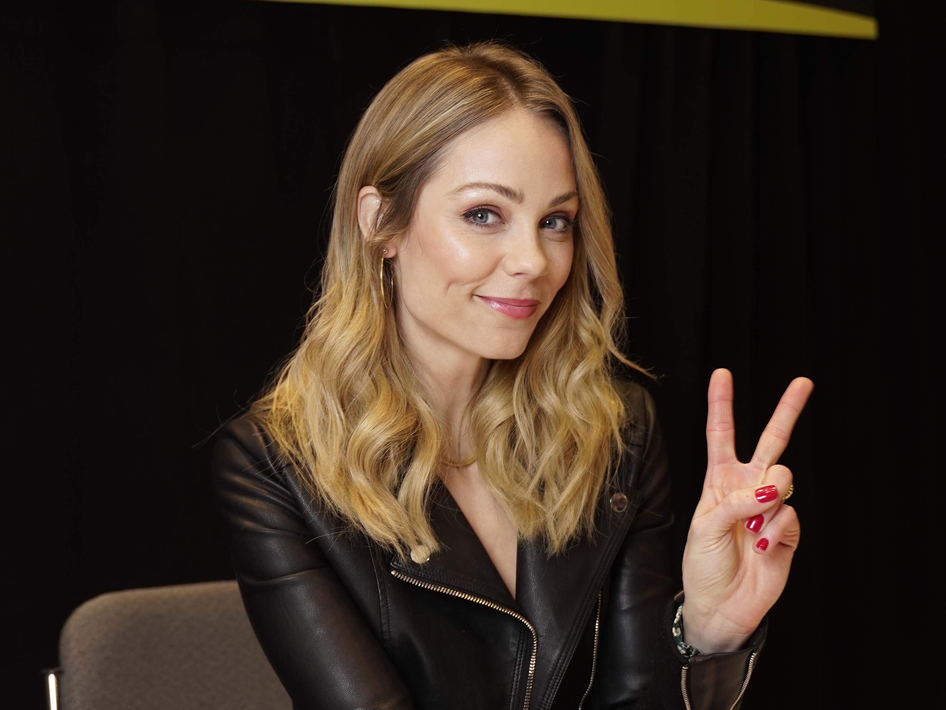 LAURA VANDERVOORT GIVING THE PEACE SIGN TO THE CAMERA