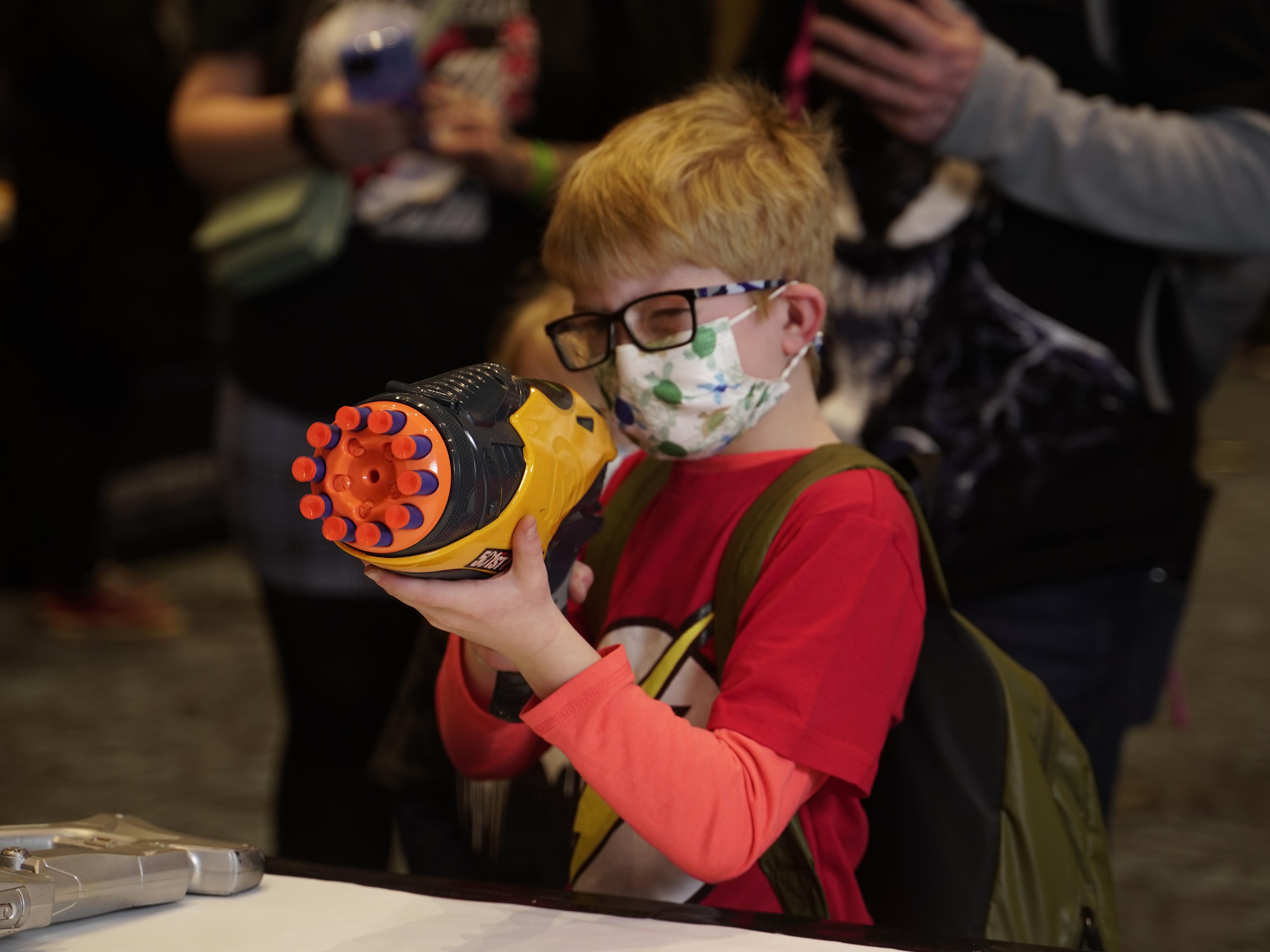 Child aiming a Nerf gun at a Storm Trooper