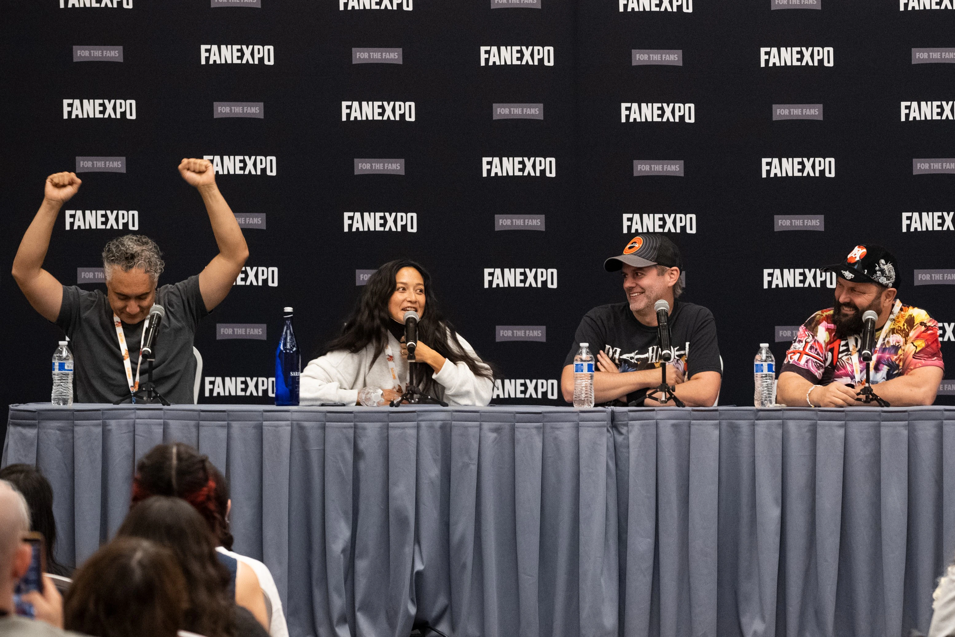 Three members of the Halo cast sit together on stage, smiling and laughing while answering questions from fans.