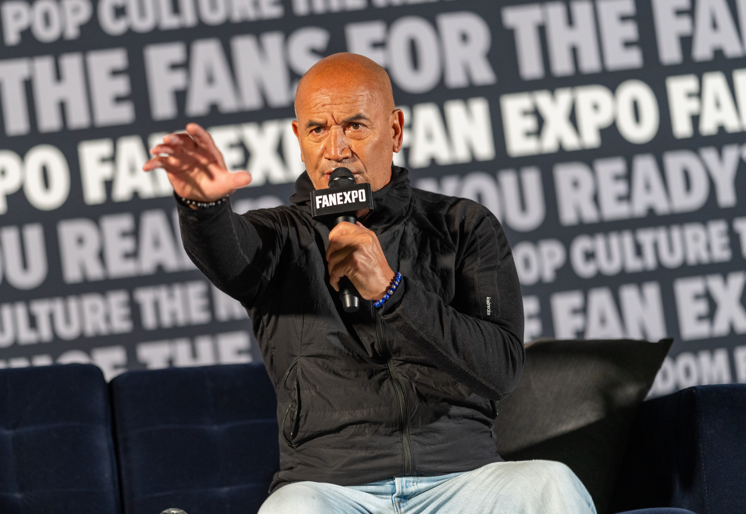Zachary Levi standing and speaking into microphone at celebrity guest panel