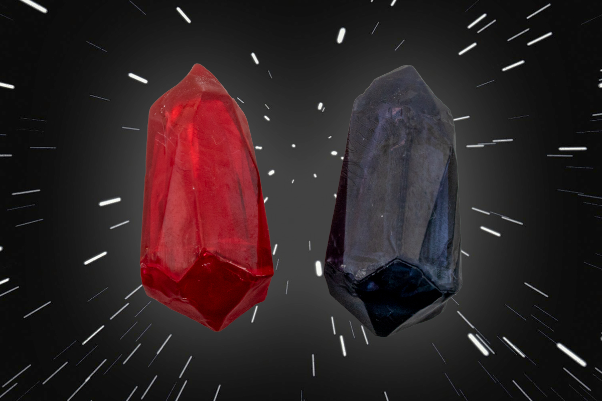 Two small plastic crystals, one black, one red, lined up side by side