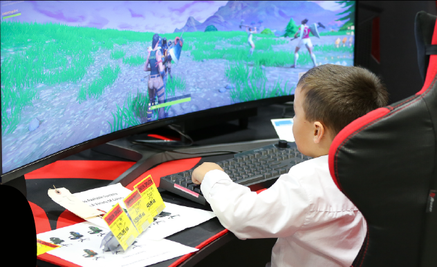 kid playing video games on a large gaming computer