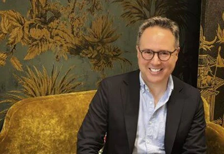 middle aged white man with glasses sitting on sofa