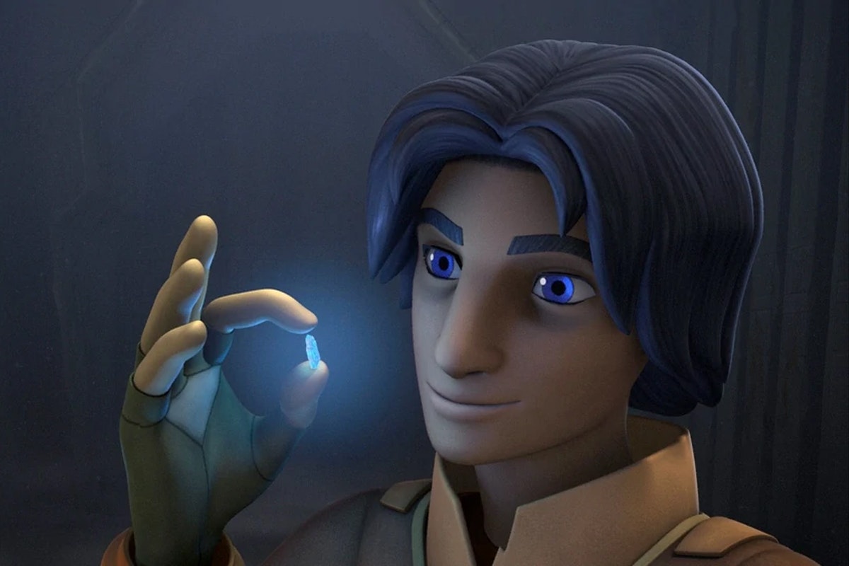 A child with long black hair holds a tiny glowing blue crystal in between his thumb and index fingers