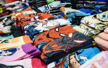 A table with a variety of nerdy socks, such as Spider-Man, SpongeBob, and Captain America.