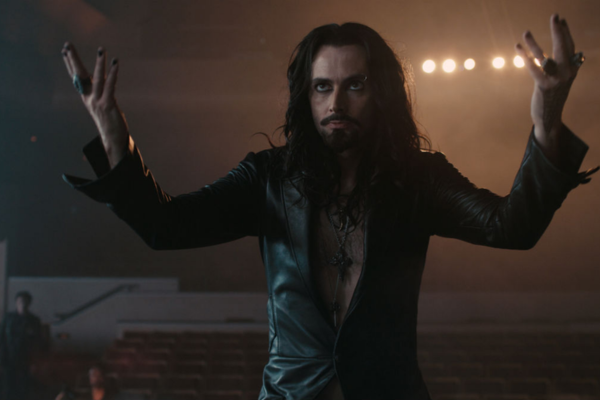 In a dark rocker look, David Tennant is glaring and has his hands raised