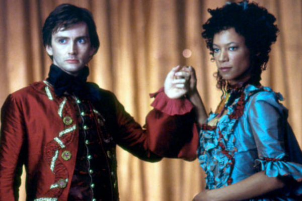 In a red flashy Rococo Style, David Tennant is holding the hand of a lady wearing a blue gown.