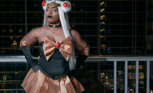 TIFFANY MZZSKITTLESTR in a black and brown outfit with a giant brown bow and black gloves