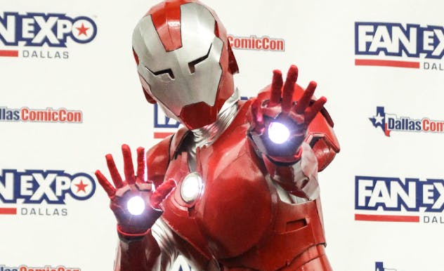 Iron Man cosplayer posing with flashing lights from hand blasters, helmet and full suit of armor