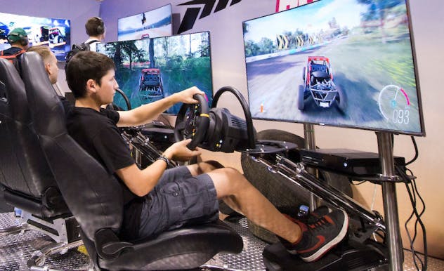 Gaming station featuring fan playing racing game