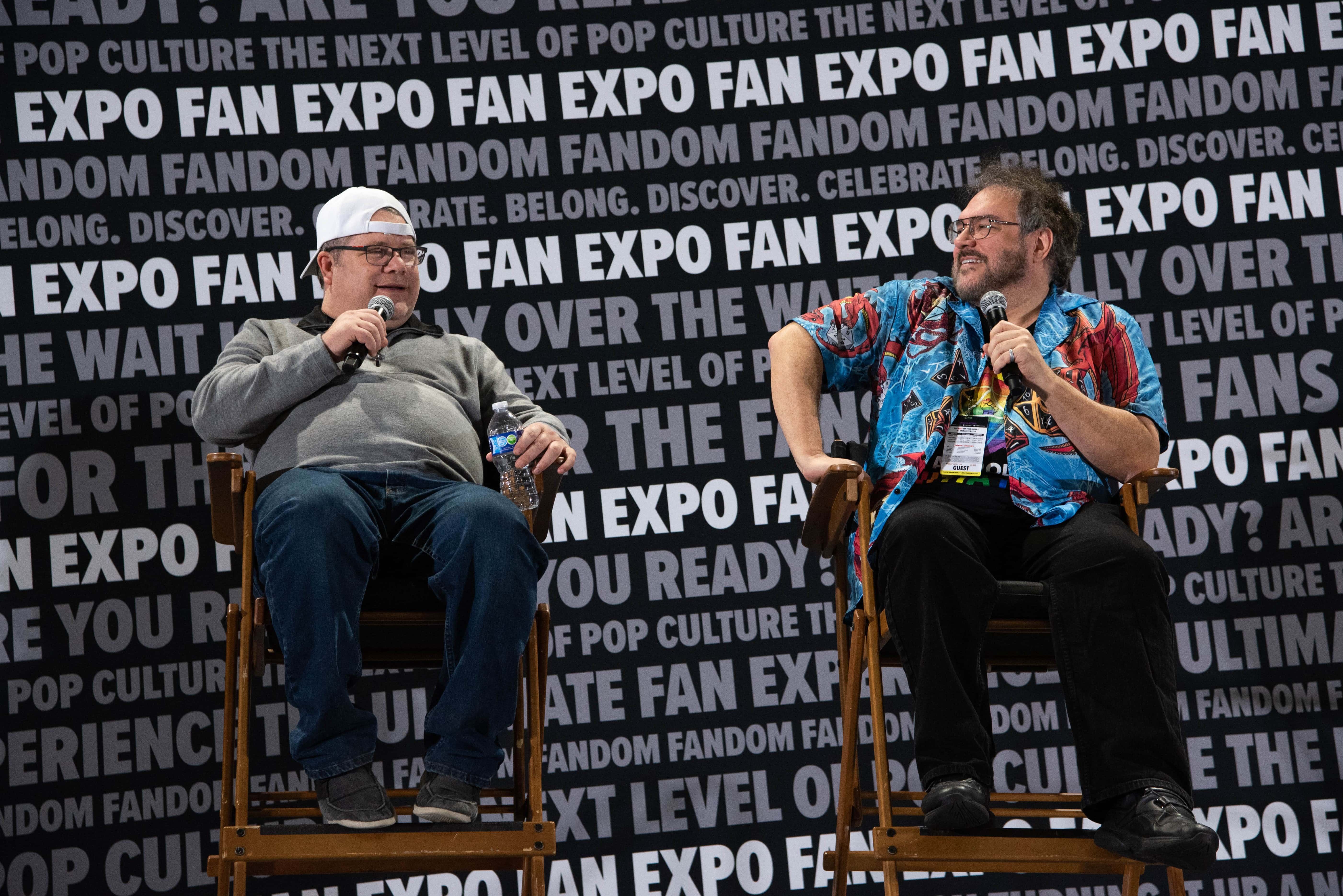 Sean Astin speaking at his panel as his moderator listens on.