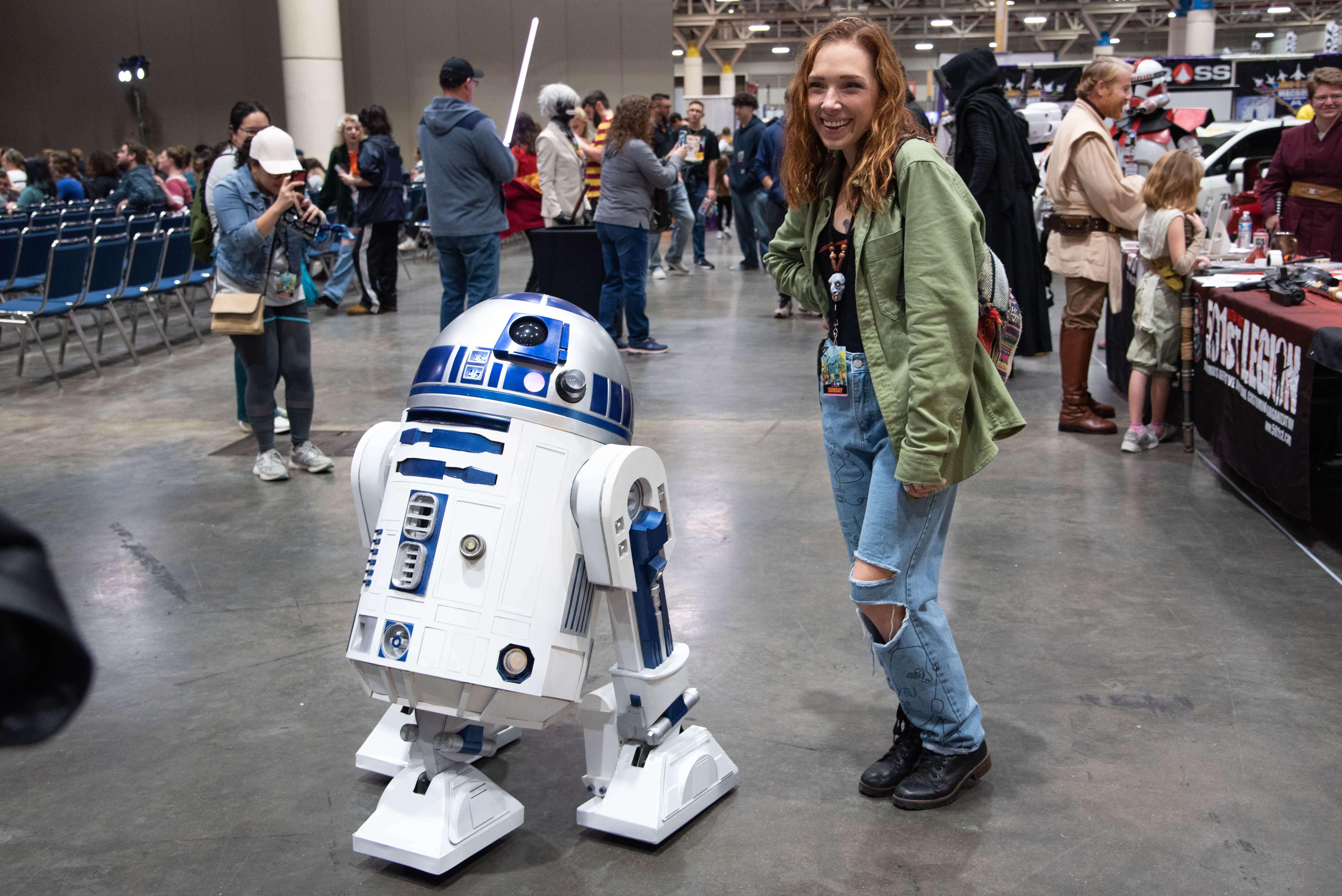 R2-D2 posing with a curious con-goer.