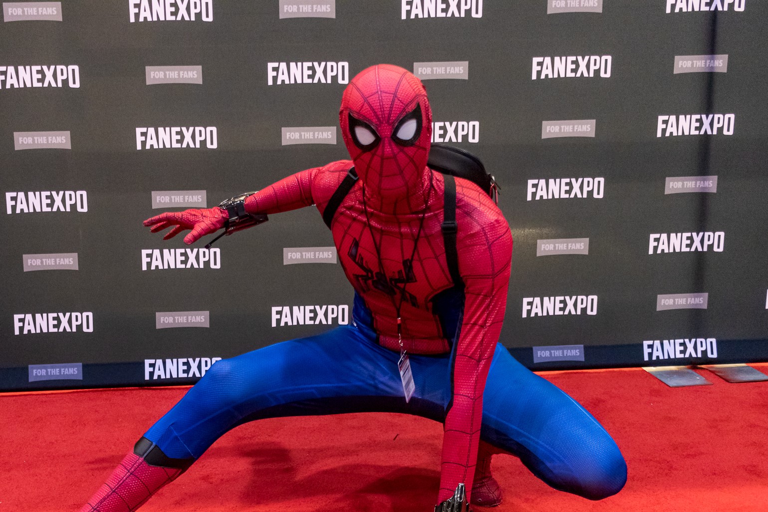 A cosplayer dressed up as Tom Holland's Spider-Man, complete with signature pose.