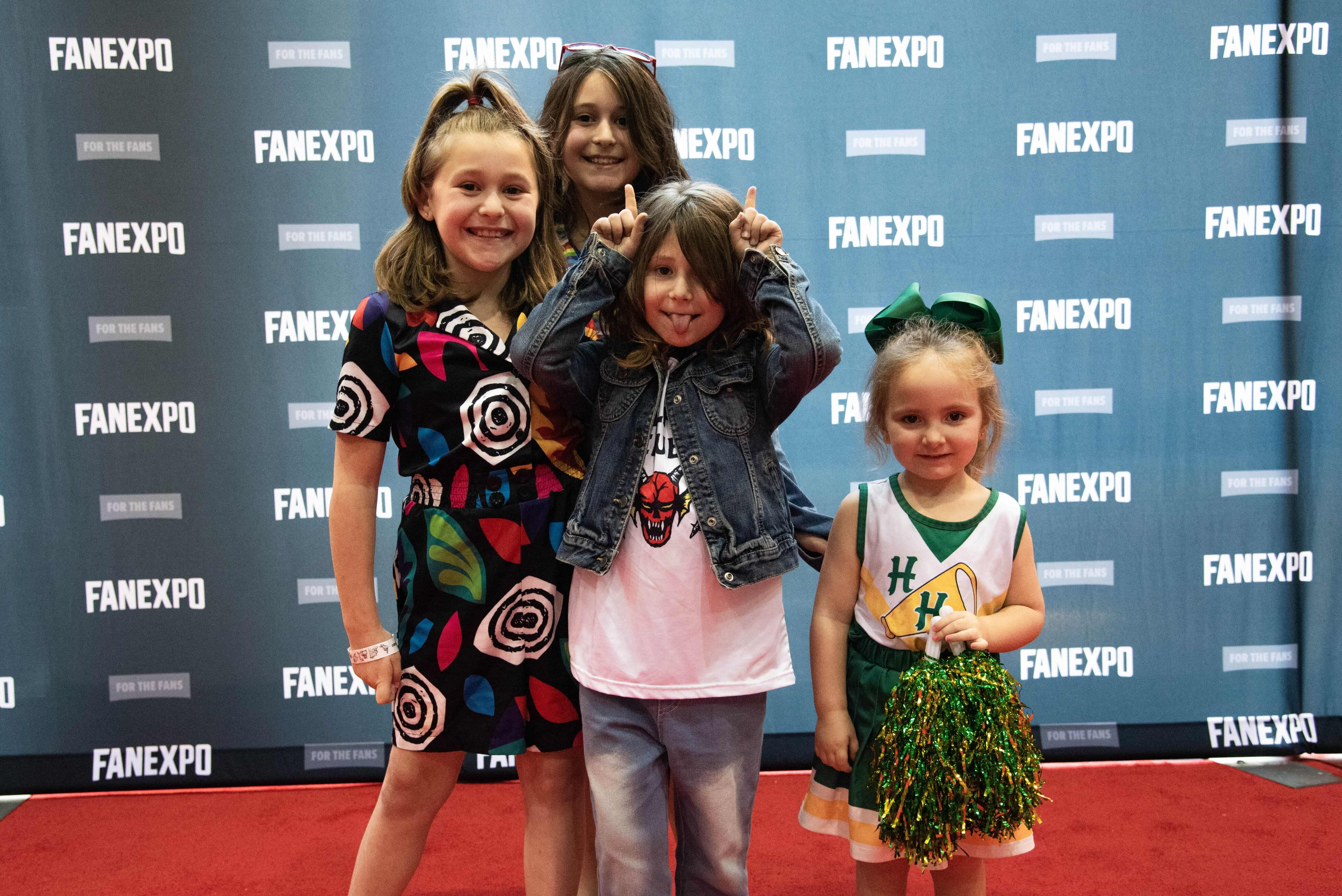 Several kid cosplayers dressed as characters from Stranger Things, including Eleven, Eddie Munson, and Chrissy.