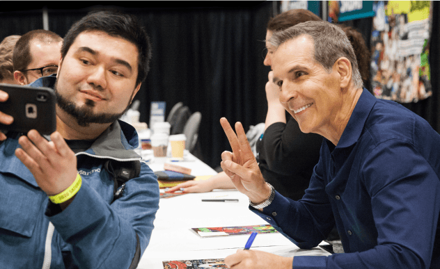 A fan taking a photo with comics artist Todd McFarlane