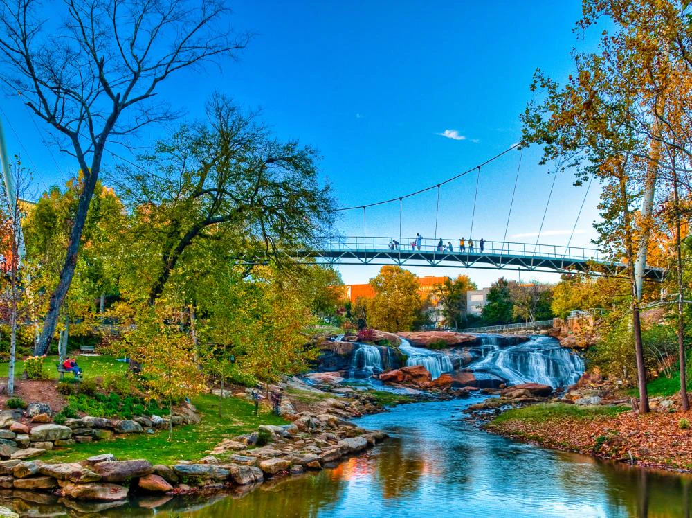 View of river and bridge during autumn in Greenville, SC