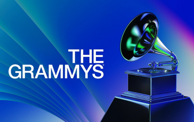 photo with blue, gradient background. Text reads "THE GRAMMYS" on the left, and on the right there is an image of The Grammy trophy award, which is shaped like a gilded gramophone.