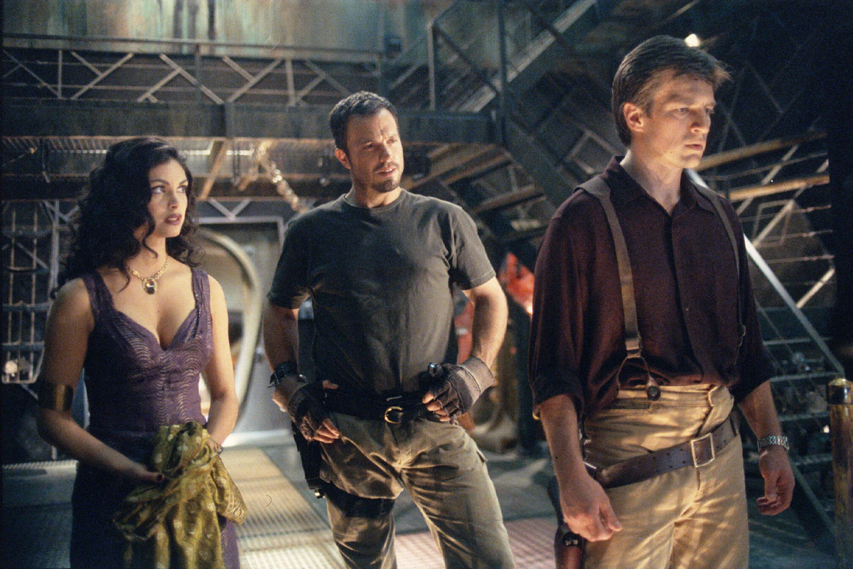 Three characters from Firefly stand and look disappointed at something to the left