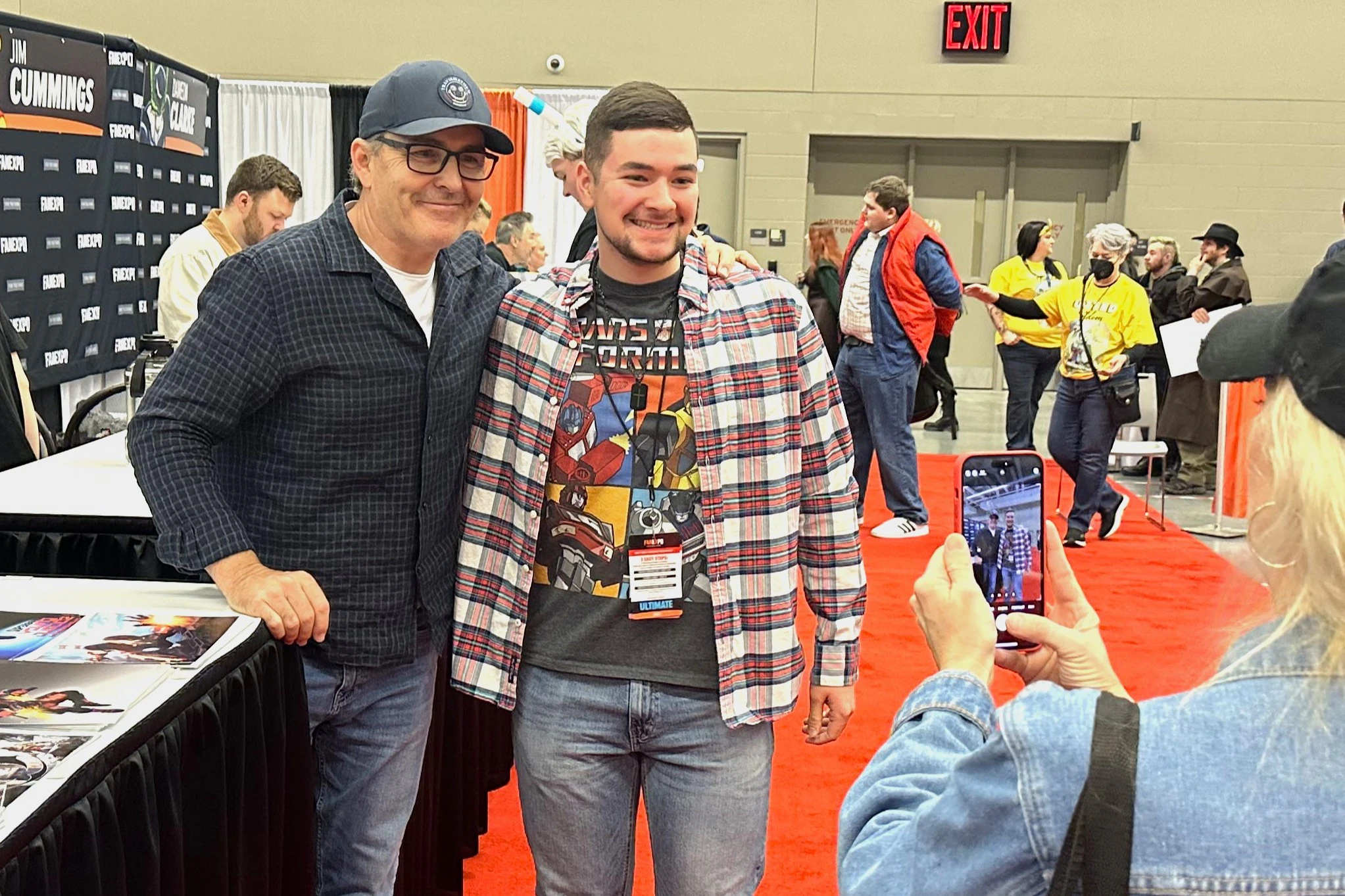Voice actor Nolan North posing for a photo with a fan at FAN EXPO Dallas.