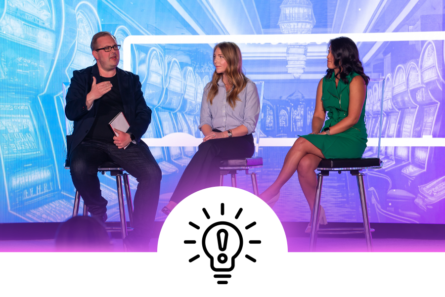 3 professionals sitting on a stage discussing educational content at a conference