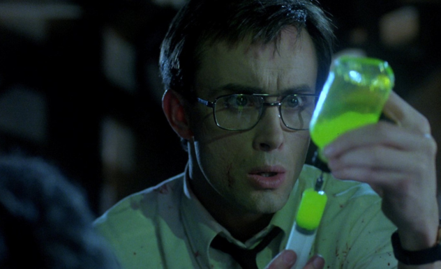 Herbert stares at his vile full of serum as he fills the syringe - the serum is fluorescent green.