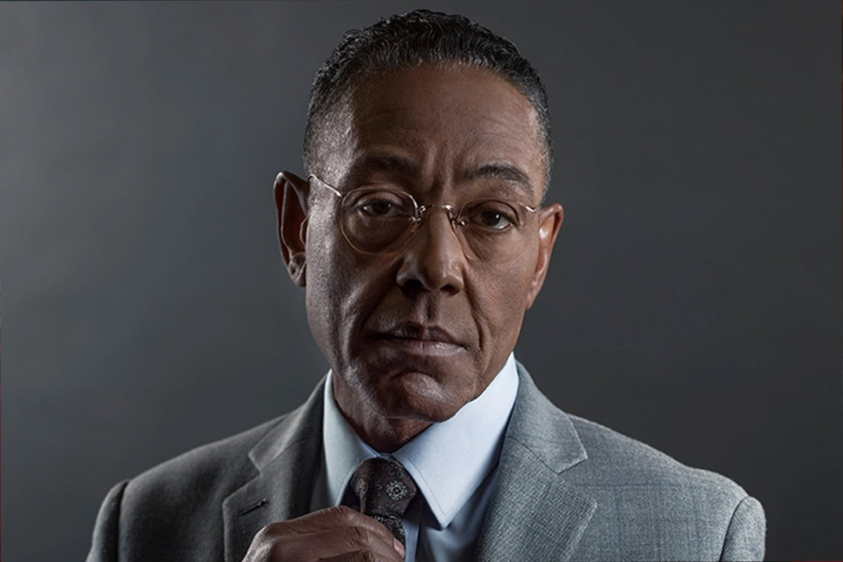 Giancarlo Esposito fixes his tie while looking very serious