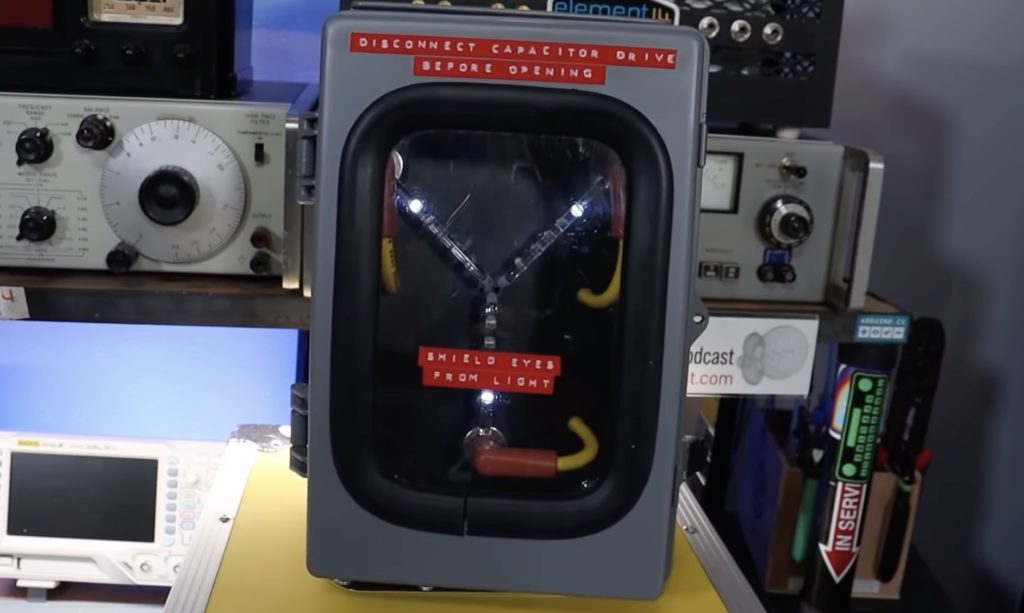 Flux capacitor (centered) surrounded by technology. Knobs, switches, and screens labelled with what each other does.