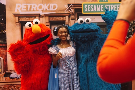 Fan poses with Sesame Street characters