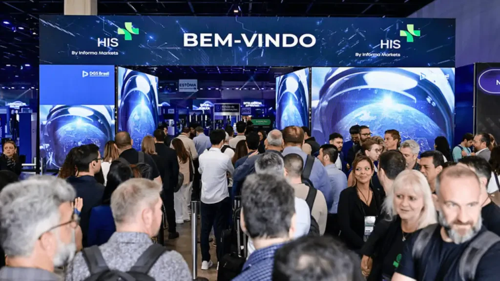 Vista do painel de entrada do evento HIS - Healthcare Innovation Show, com a inscrição "BEM-VINDO" e o logotipo da Informa Markets, cercado por uma multidão de participantes na feira de tecnologia em saúde.