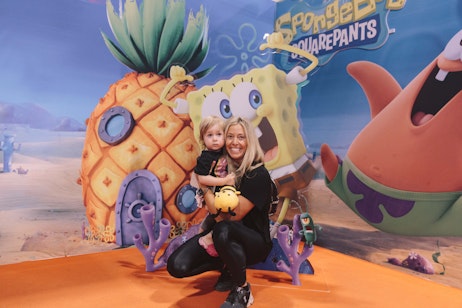 Cute child with mother in front of Spongebob background