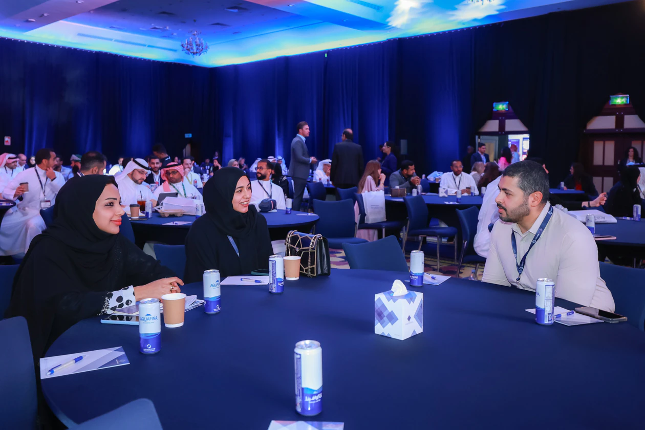 Attendees engaging in conversation at a conference table.