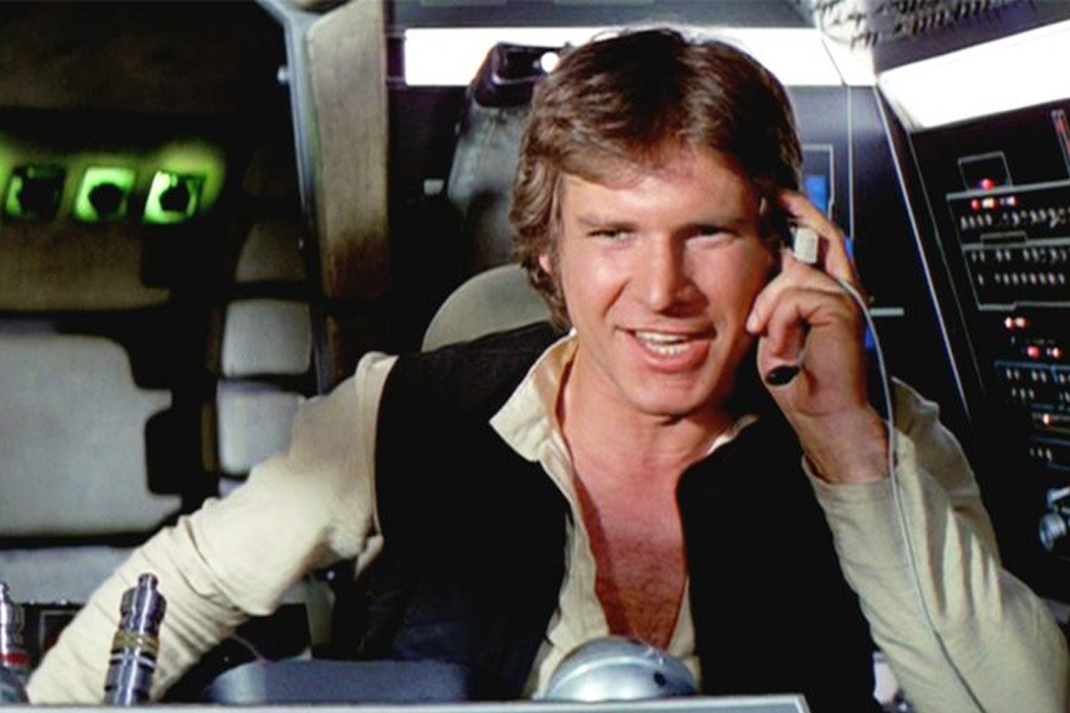 Han Solo smiles and touches his head aboard the Millenium Falcon