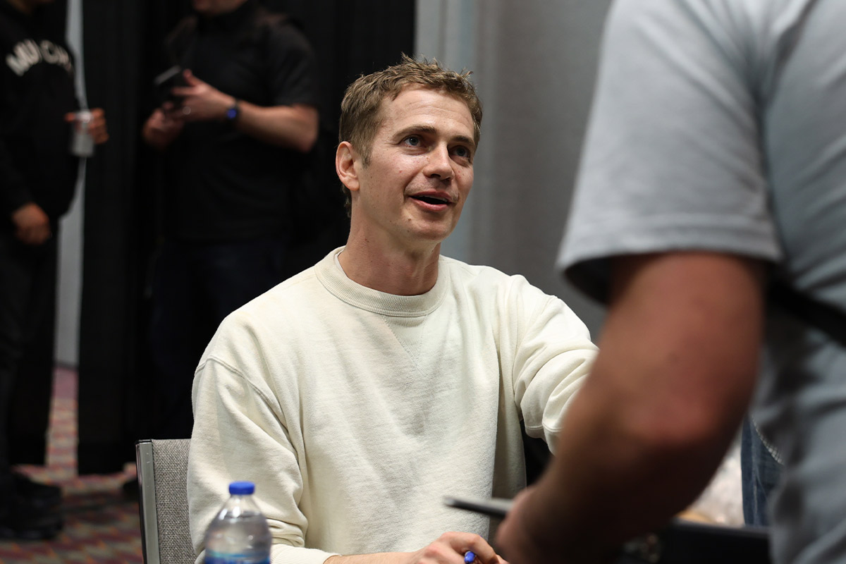 Hayden Christensen smiles while looking up at a fan
