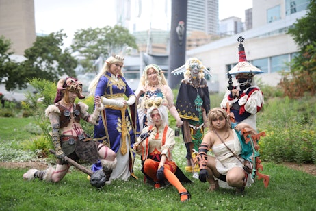 Cosplayers pose outside the convention centre on the grass