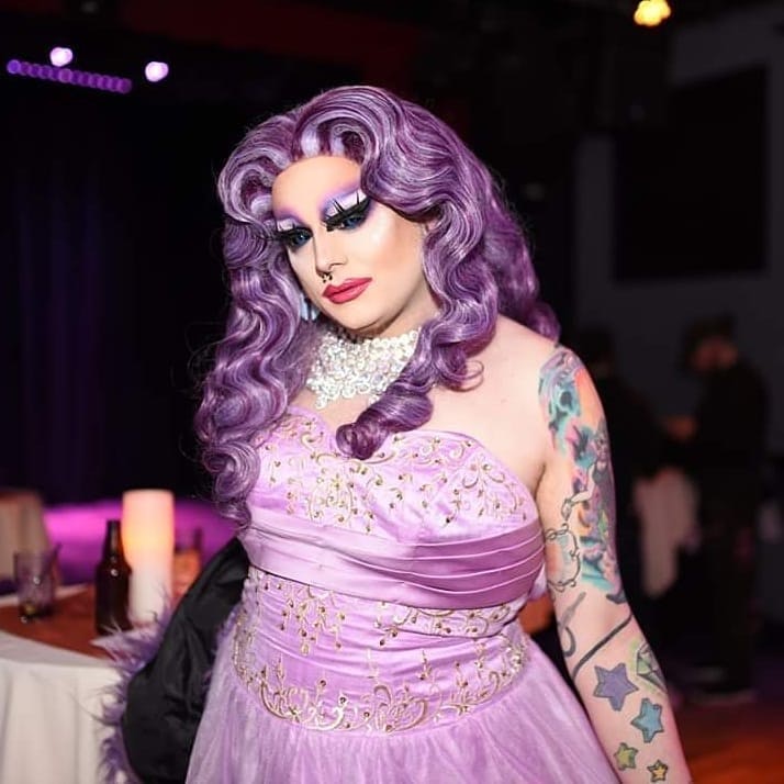 VIOLENCIA EXCLAMATION POINT IN A PURPLE DRESS AND PURPLE WIG