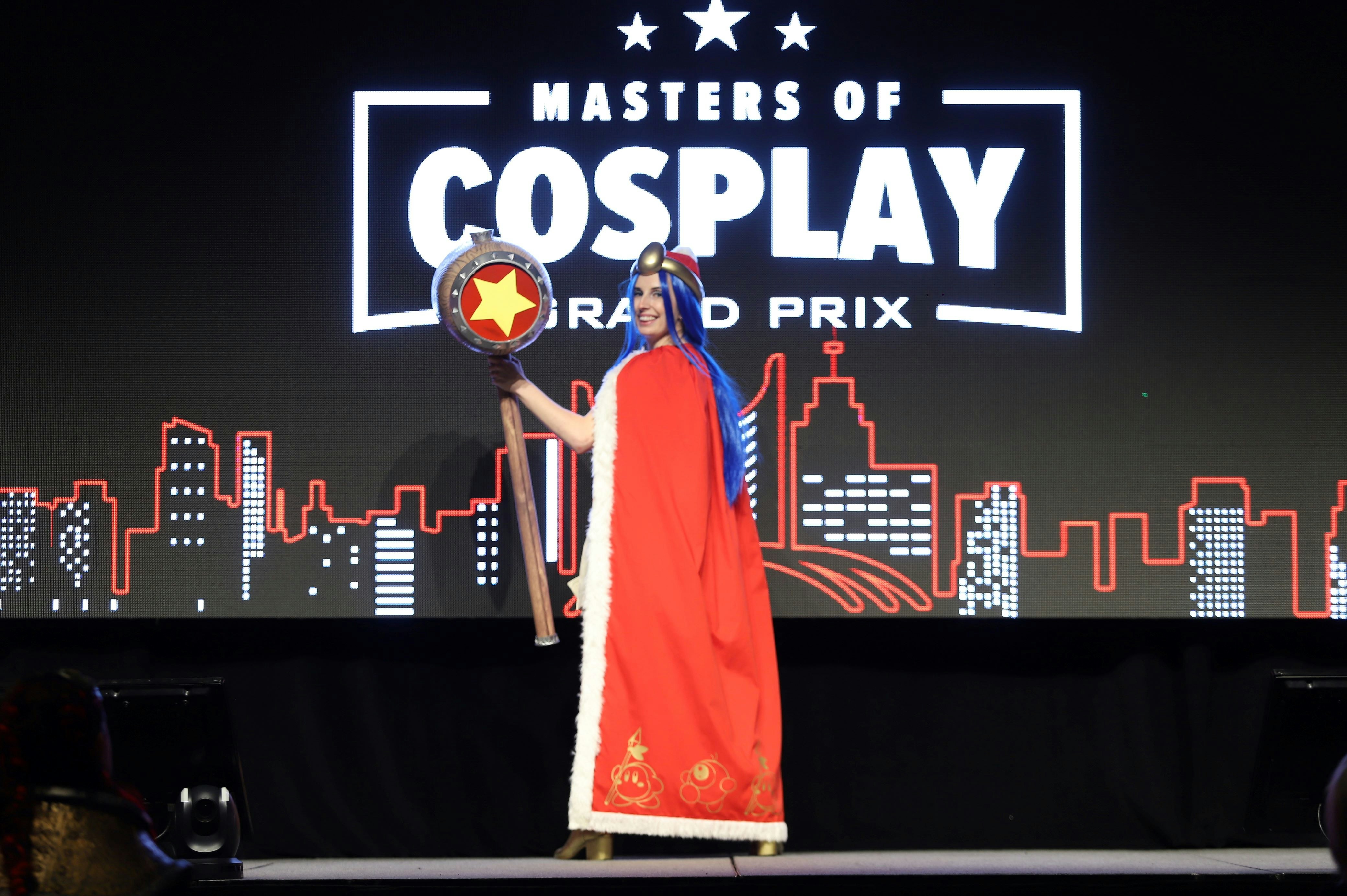 cosplayer poses on stage during cosplay grand prix