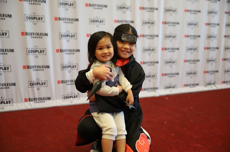 Child poses in cosplay with mother on the red carpet