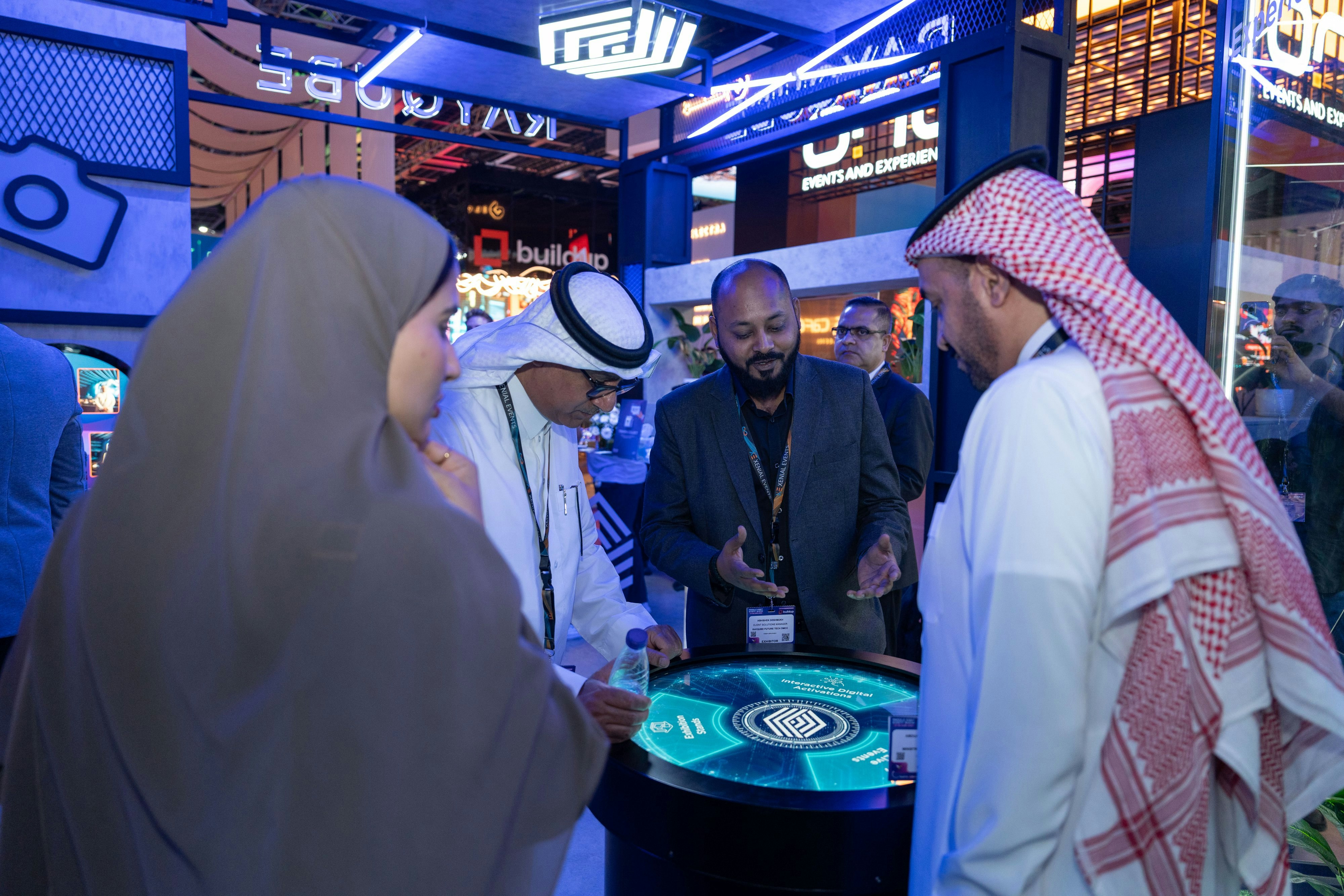 Exhibitors demonstrating interactive event technology to attendees at MEES, showcasing innovation at Dubai World Trade Centre.