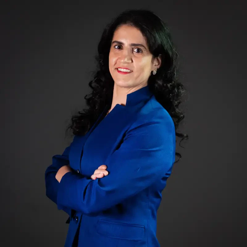 Jihan Zoghbi, palestrante do Healthcare Innovation Show, mulher de cabelos escuros ondulados e blazer azul.