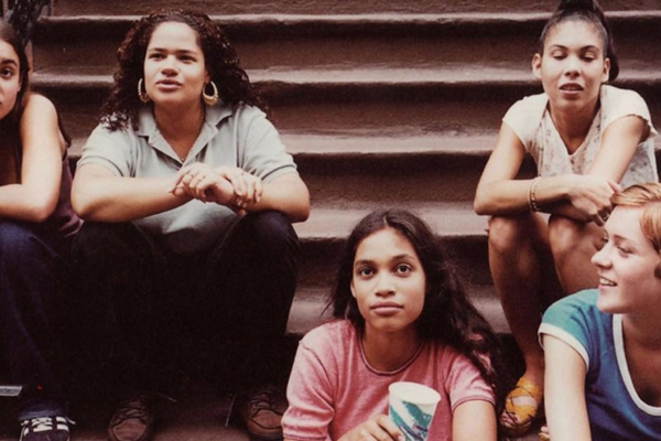 A few teenagers sitting on the stairs of an apartment building, talking to each other.