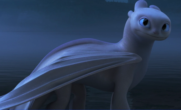 A white dragon with blue eyes walks alongside the water. Its features are soft with minimal scale patterns