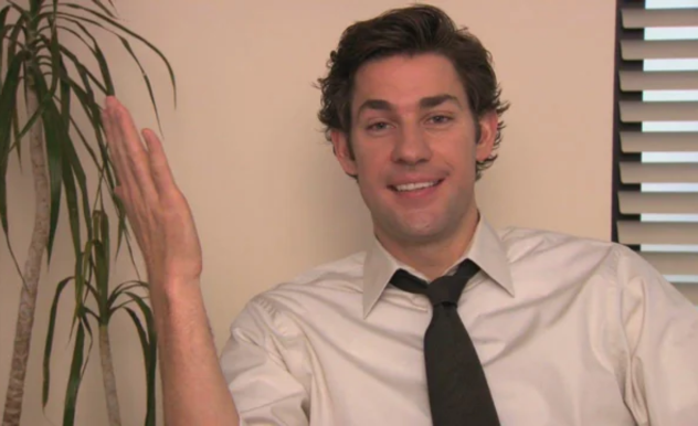 With his arms up in a shrug, Jim smiles at the camera