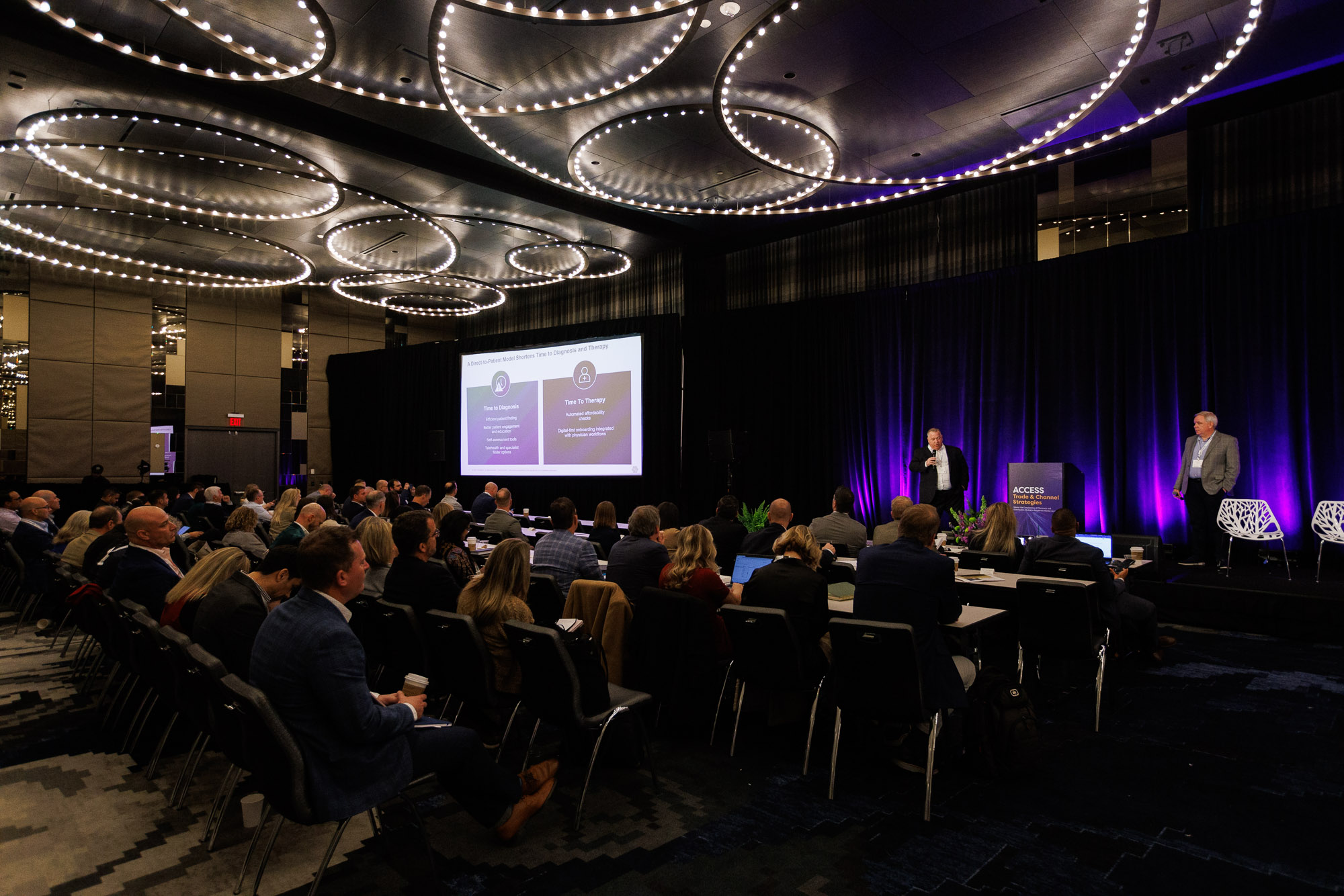 A full room of attendees listen to co-presenters deliver a presentation at Trade and Channel Strategies
