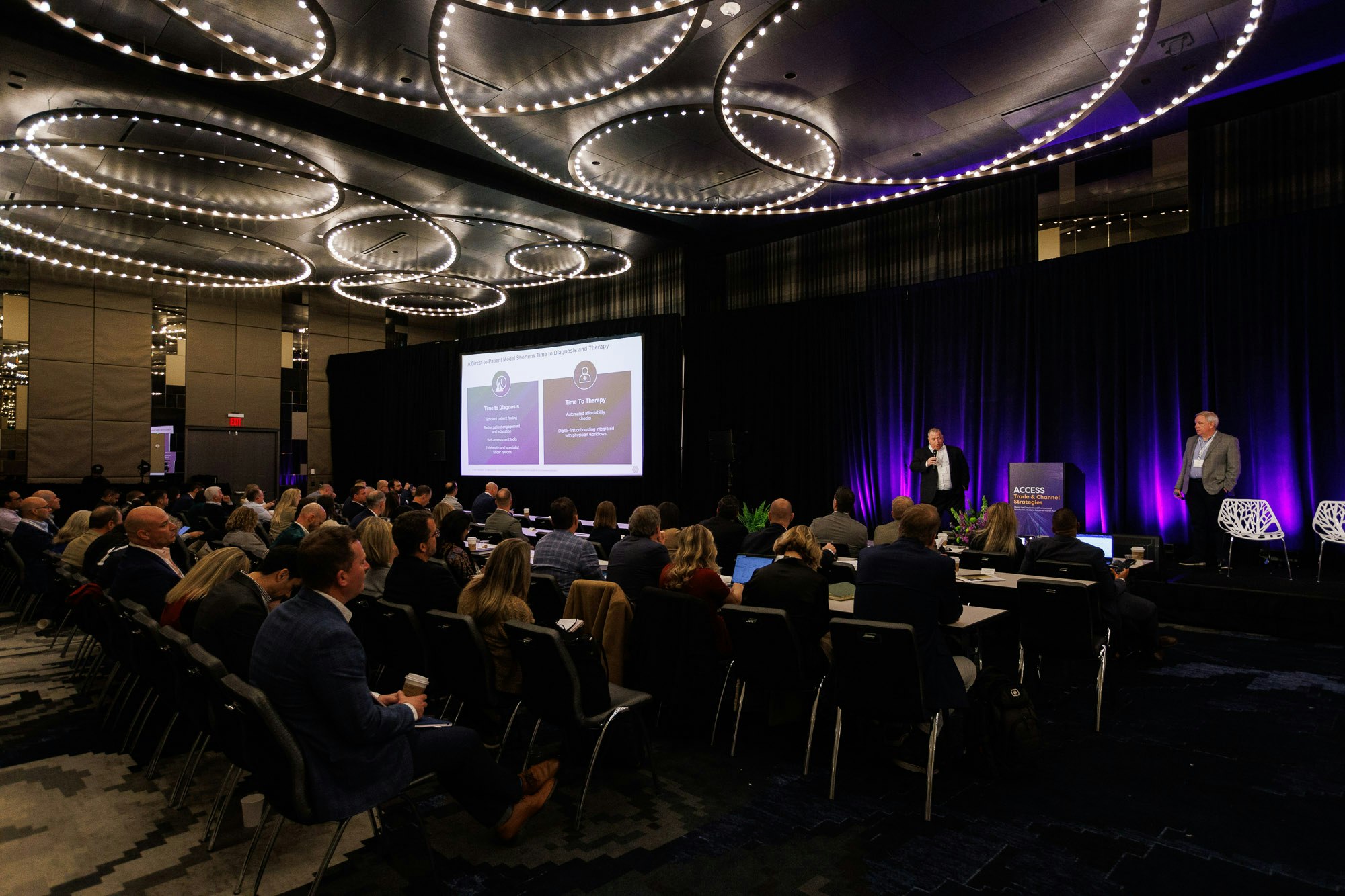 A full room of attendees listen to co-presenters deliver a presentation at Trade and Channel Strategies