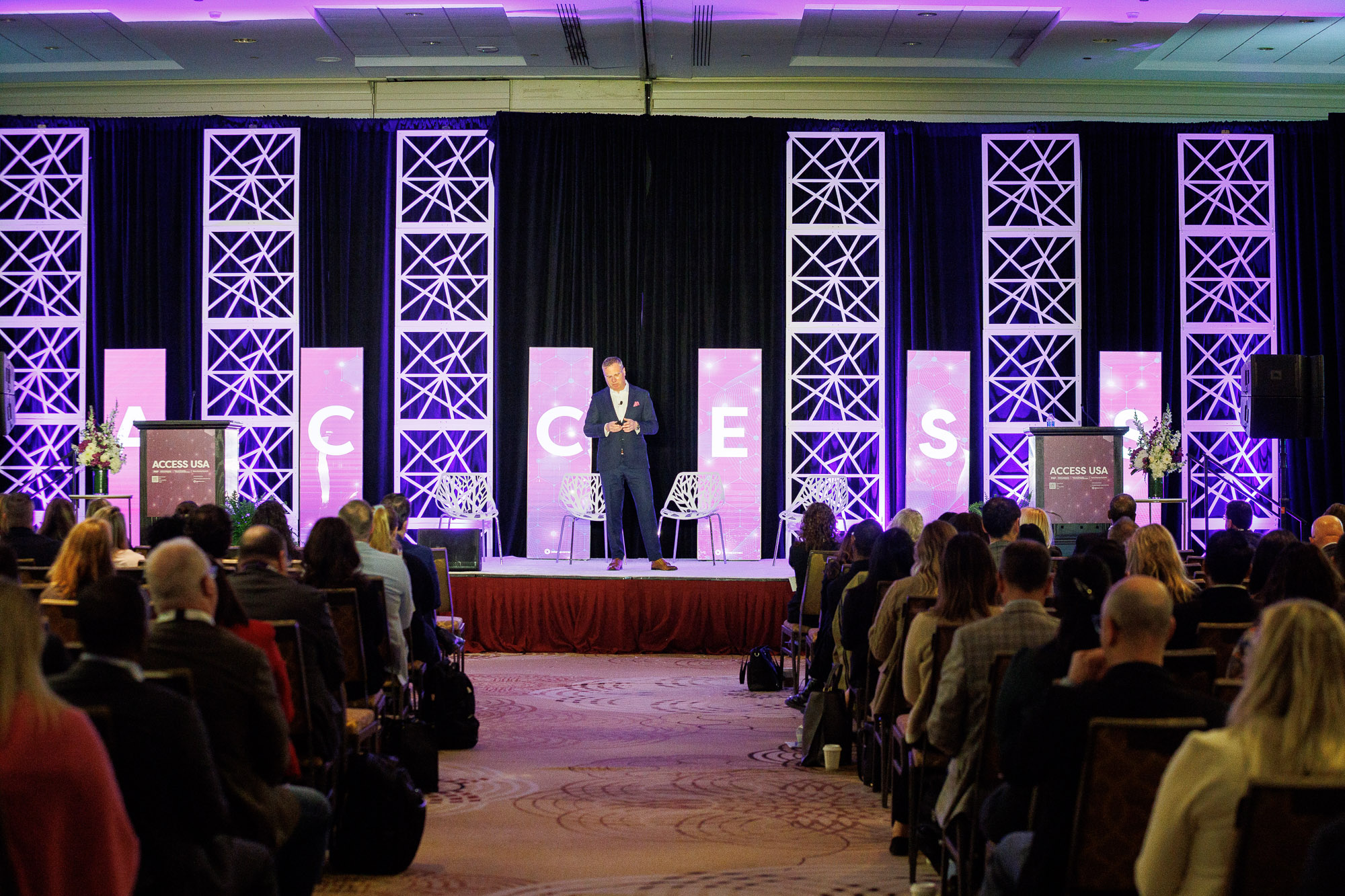 Pharmaceutical professional presenting to a seated audience at Access USA conference