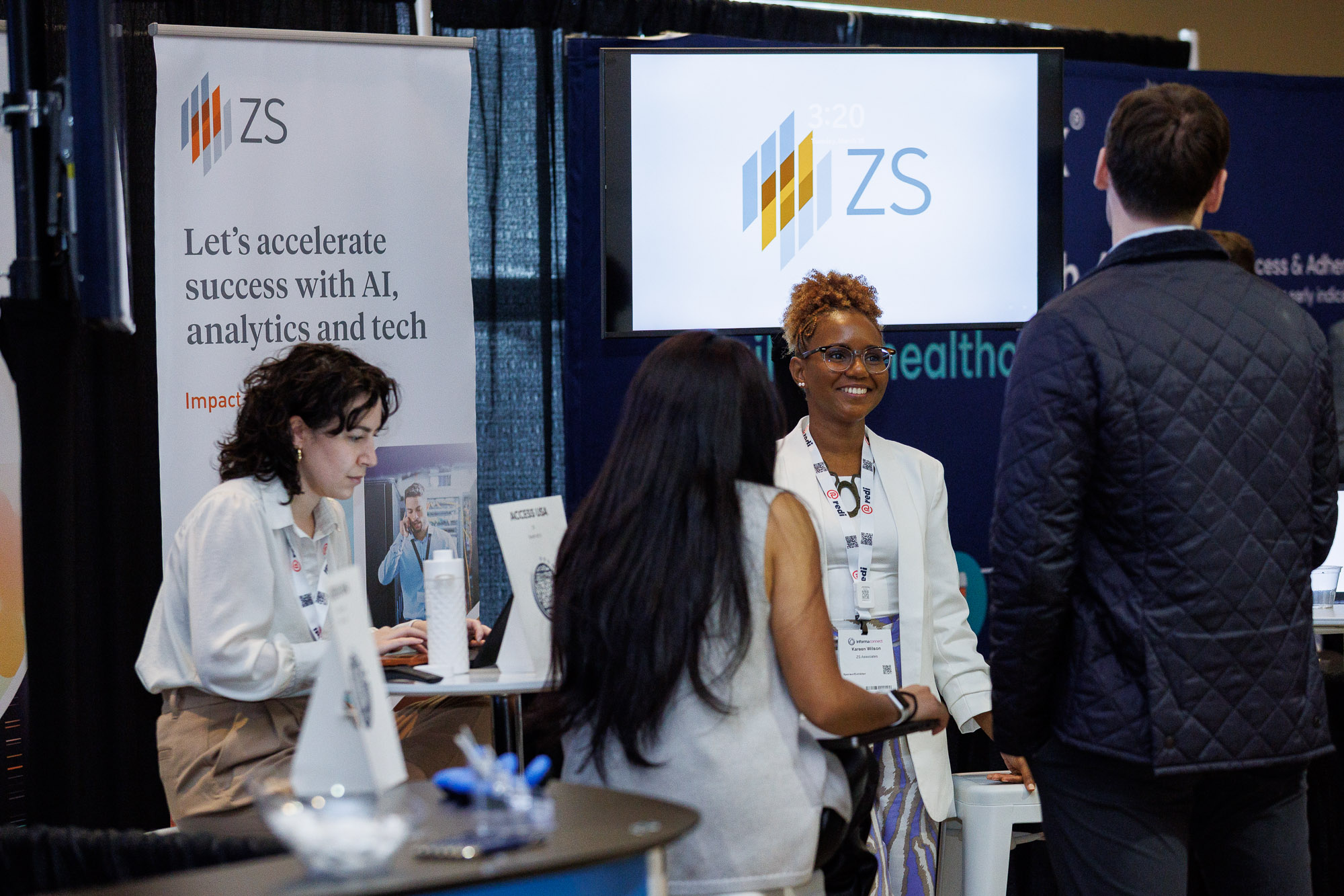 Exhibitors and attendees in conversation at Patient Assistance & Access Programs conference