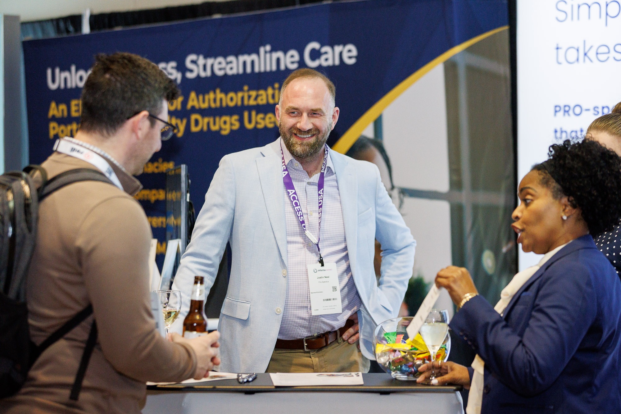 Three Access USA attendees in conversation in the exhibit hall at the conference