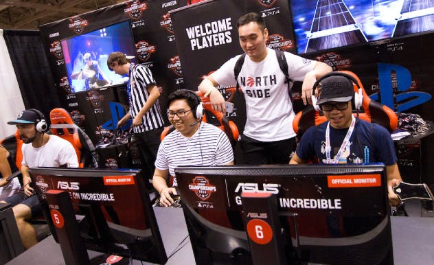 Fans play video games at a gaming booth at MEGACON Orlando