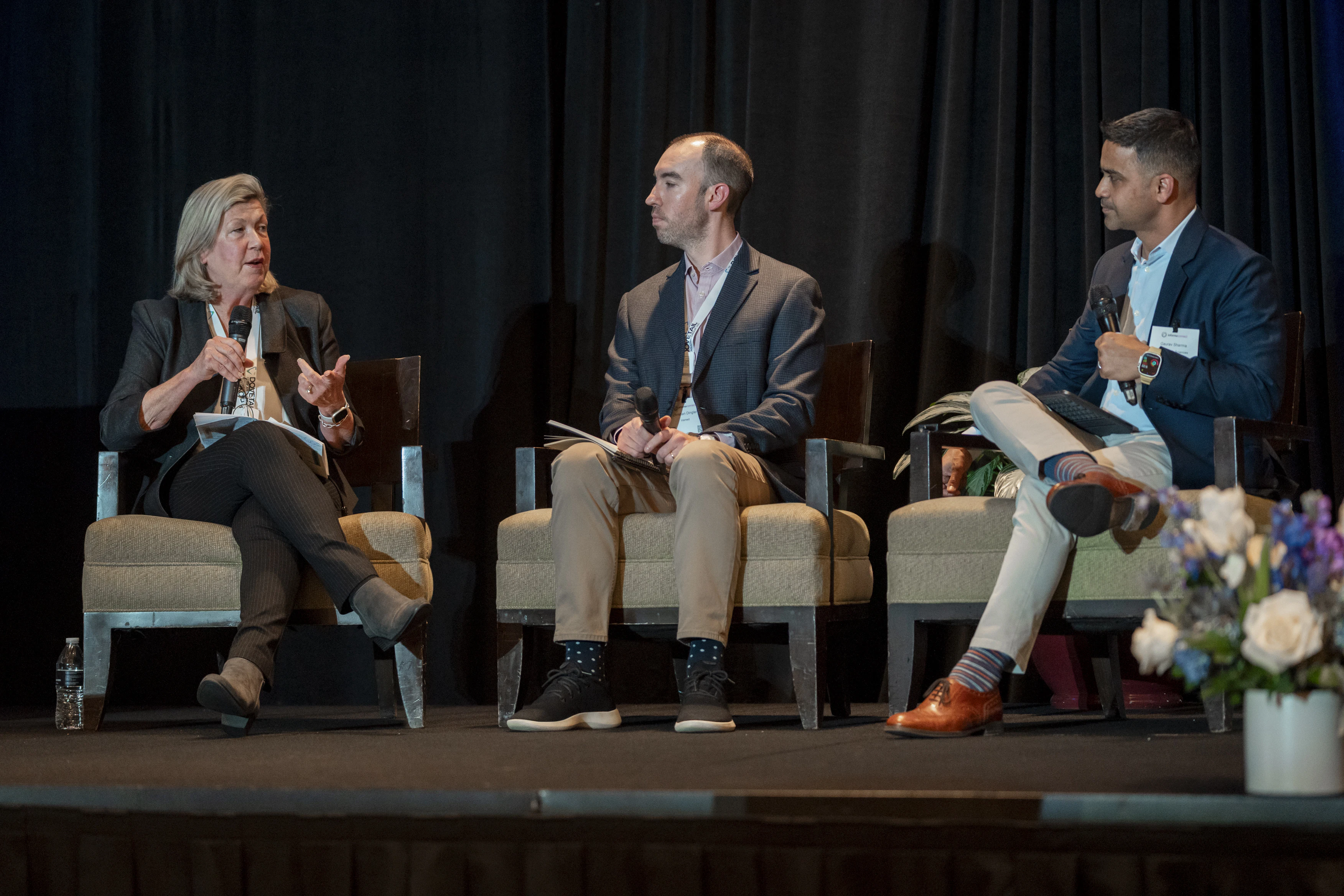 Three speakers chat on stage at MDRP Summit